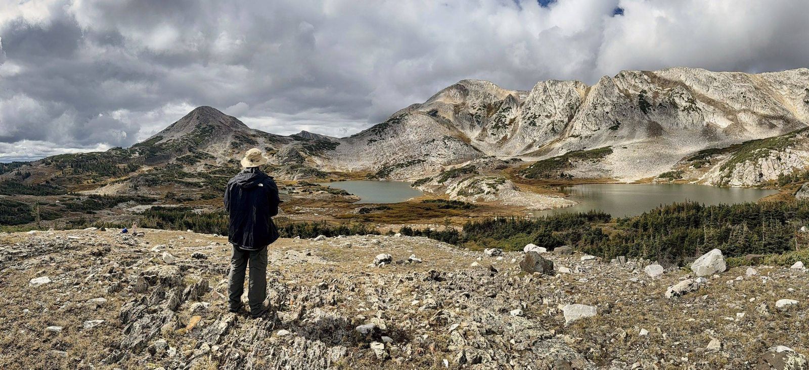 The original photograph: a man standing above an alpine lake