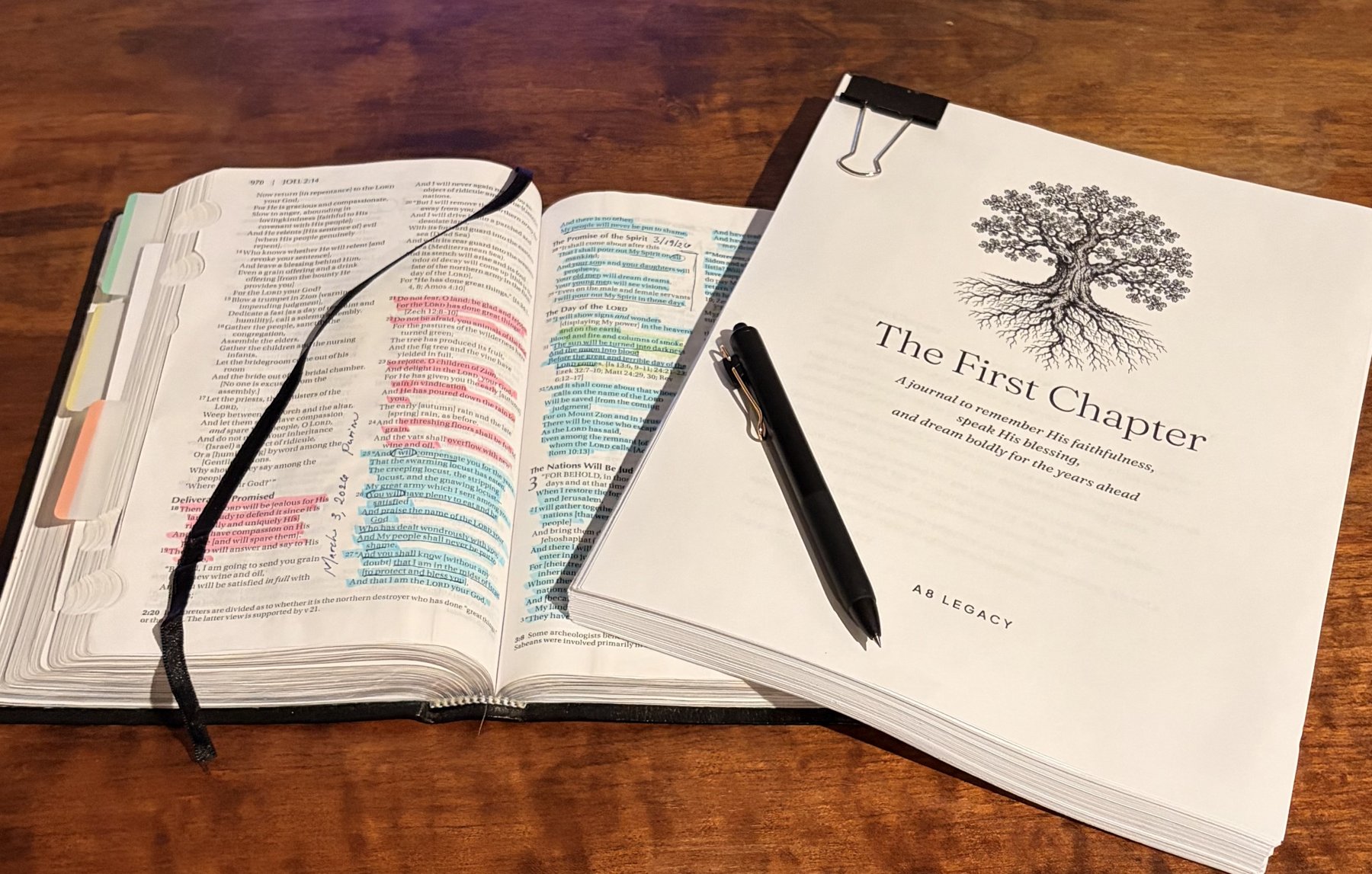 Jenny's own Bible, highlighted and tabbed, beside The First Chapter journal and a pen